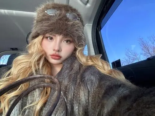 Anh-MaiQuinn-hinh-nen-ngang-3 Ảnh MaiQuinn hình nền ngang ngồi trong xe, đội mũ lông và nhìn thẳng máy ảnh