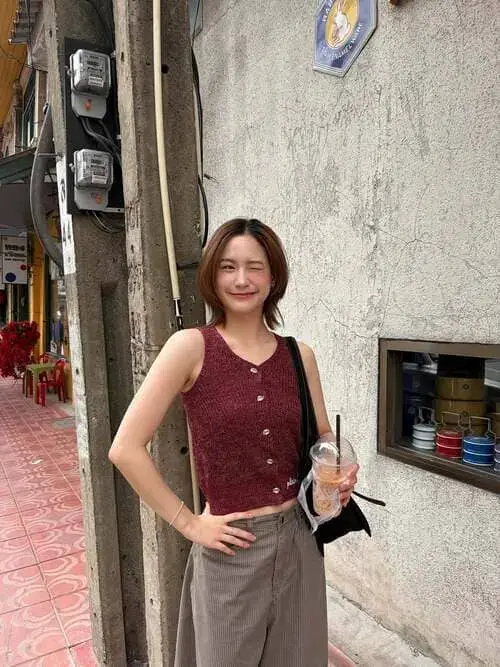 yu-ornicha-ongsritrakul-hinh-anh-1 Yuyu Ornicha Ongsritrakul diện áo len đỏ đô phối quần ống rộng, cầm ly nước đứng trên con phố nhỏ